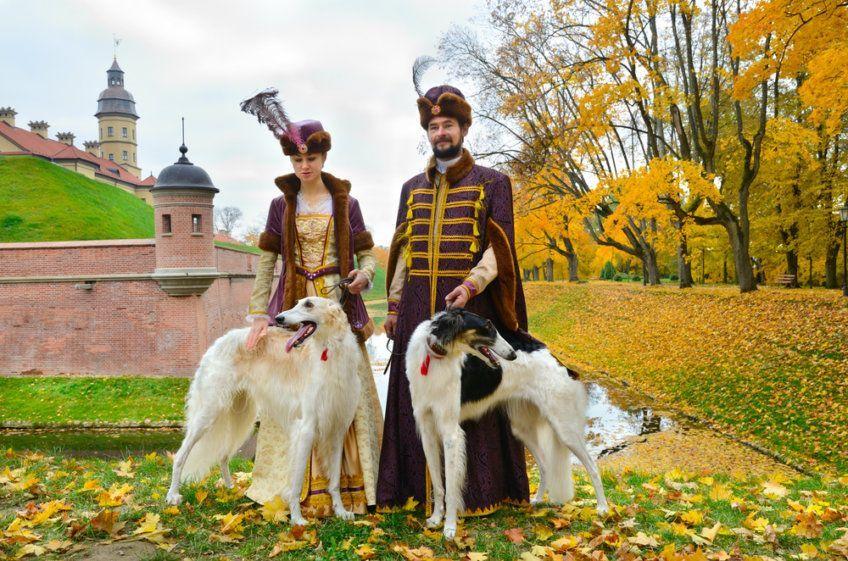 Para w tradycyjnych średniowiecznych kostiumach z dwoma psami